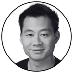 Black and white circular headshot of Justin Kan smiling against a light gray background.