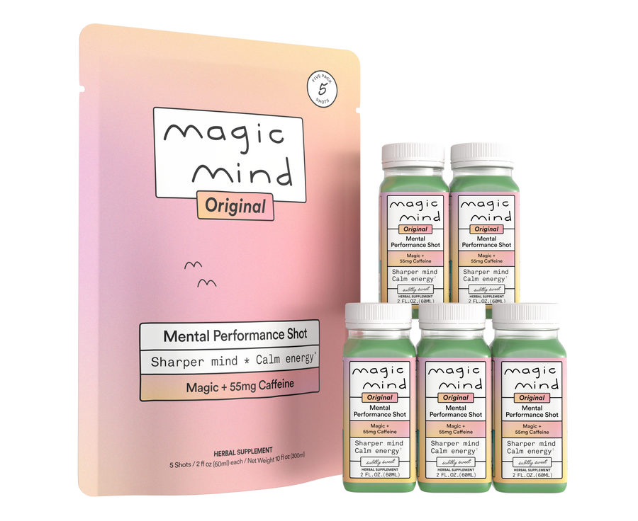 Five bottles of Magic Mind Original Mental Performance Shot with green liquid and white caps next to packaging box on pink gr